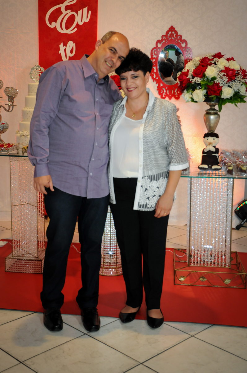 foto do casal em frente a mesa decorada bodas de prata no Buffet Fábrica da Alegria, osasco, sp
