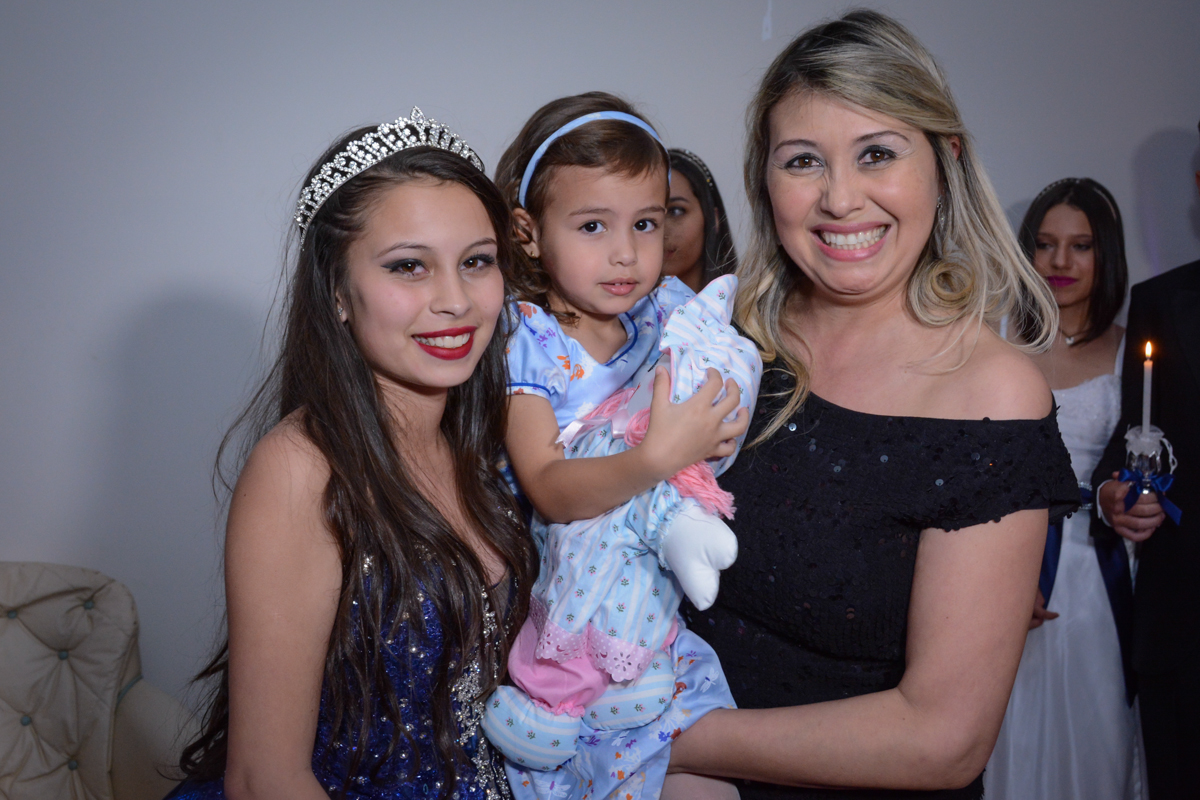A aniversariante de 15 anos entrega a boneca para uma criança em sua festa de 15 anos no Salão de festas, butantã,São Paulo, SP