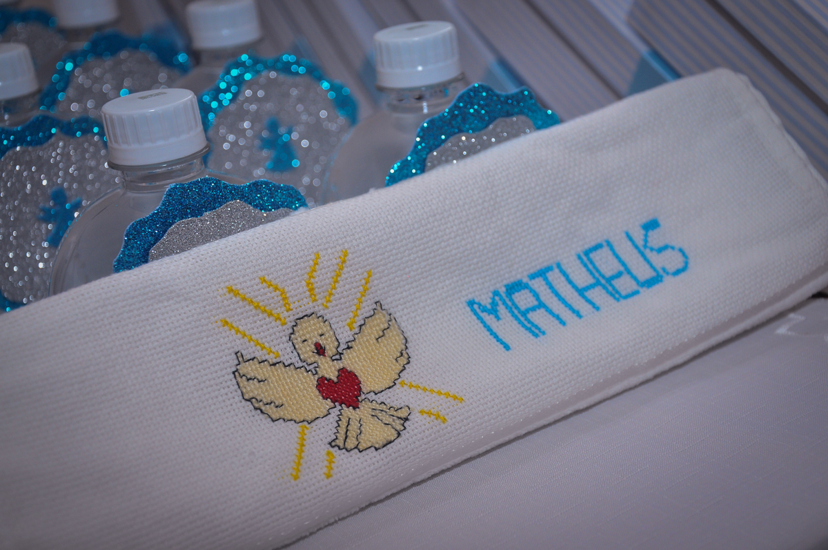 A toalha bordada com o nome do Matheus e a pombinha da paz festa no condomínio