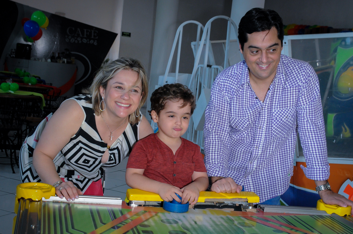Enrico joga futebol de mesa com seus pais no Buffet Fábrica da Alegria Morumbi
