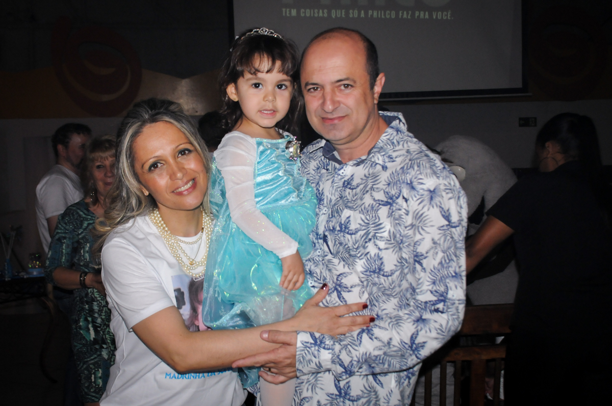 sophia é fotografada com os padrinhos no Buffet Fábrica da Alegria, Morumbi
