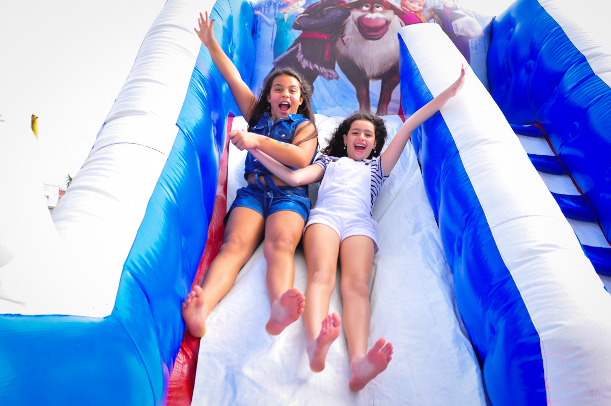 agora camile é uma garotinha brincando no escorregador inflável no Condomínio São Paulo, SP, tema da festa Frozen