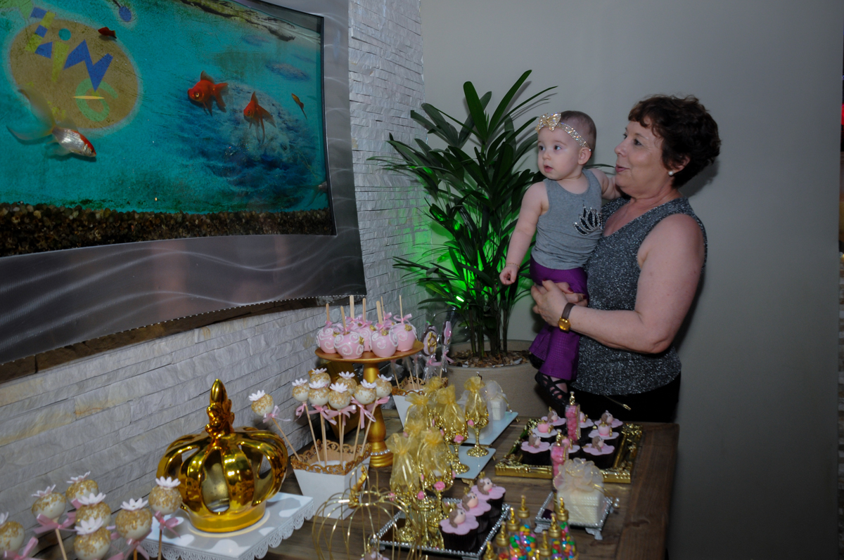 a aniversariante se diverte na mesa de guloseimas no buffet amazing, alphaville,sp, tema da mesa bonecas princesas