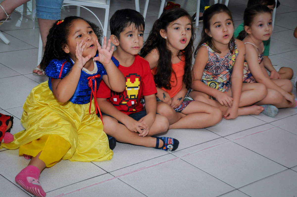 as crianças ficam atentas ao show do mágico no Buffet Paparicos, festa infantil, tema da mesa dinossauros, guilherme 5 anos