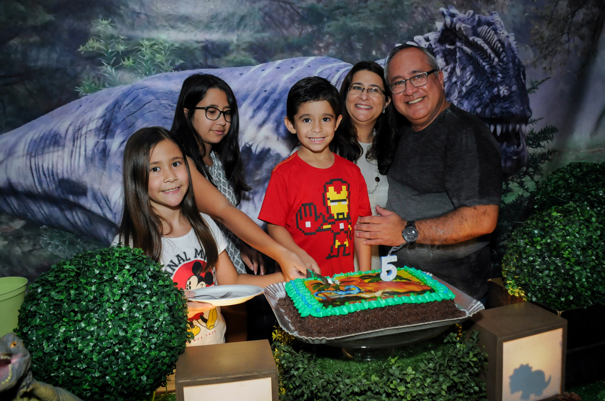 cortando o primeiro pedaço de bolo no Buffet Paparicos, festa infantil, tema da mesa dinossauros, guilherme 5 anos