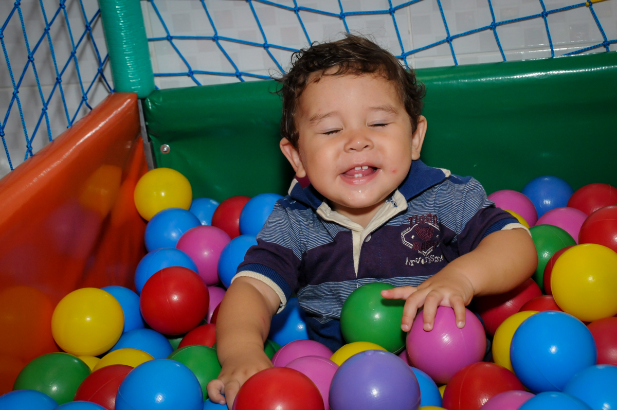 Pietro faz careta enquanto brinca n iscina de bolinha