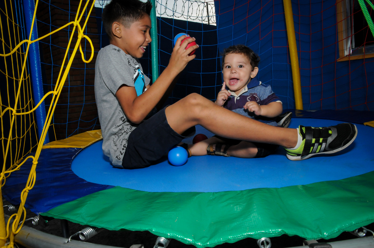 o aniversariante brinca com o irmao na cama elastica na Festa Infantil, no condominio Osaco, SP, tema Galinha Pintadinha, Pietro 1 aninho