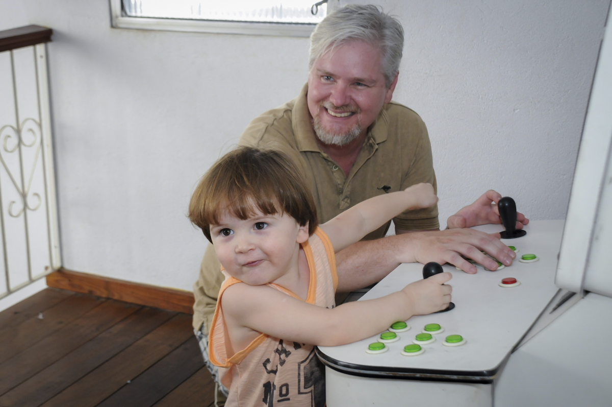 pai e filho brincam no game no  buffet feliz da vida, festa infantil Théo 3 aninhos, tema da festa carros