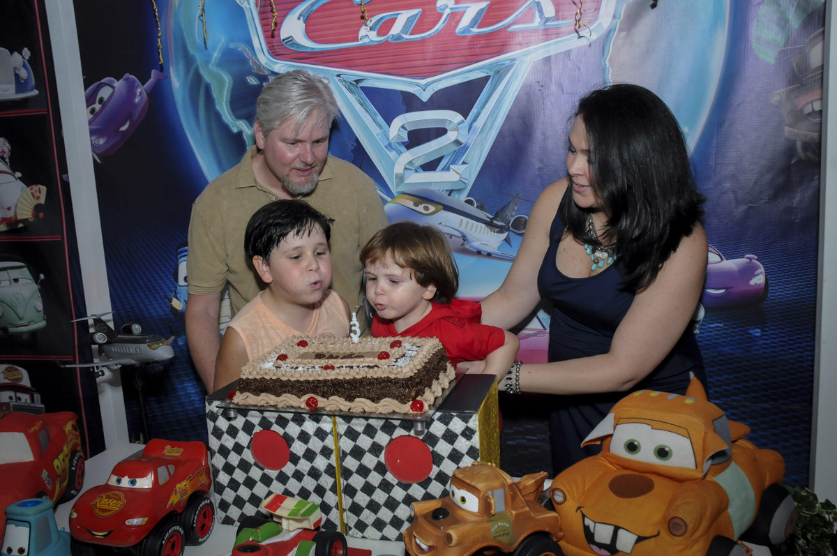 soprando a velinha do bolo no  buffet feliz da vida, festa infantil Théo 3 aninhos, tema da festa carros