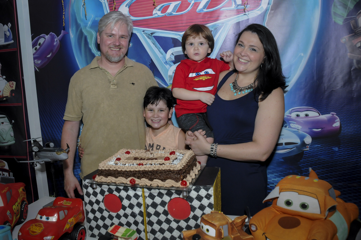 foto da família na mesa do bolo no  buffet feliz da vida, festa infantil Théo 3 aninhos, tema da festa carros