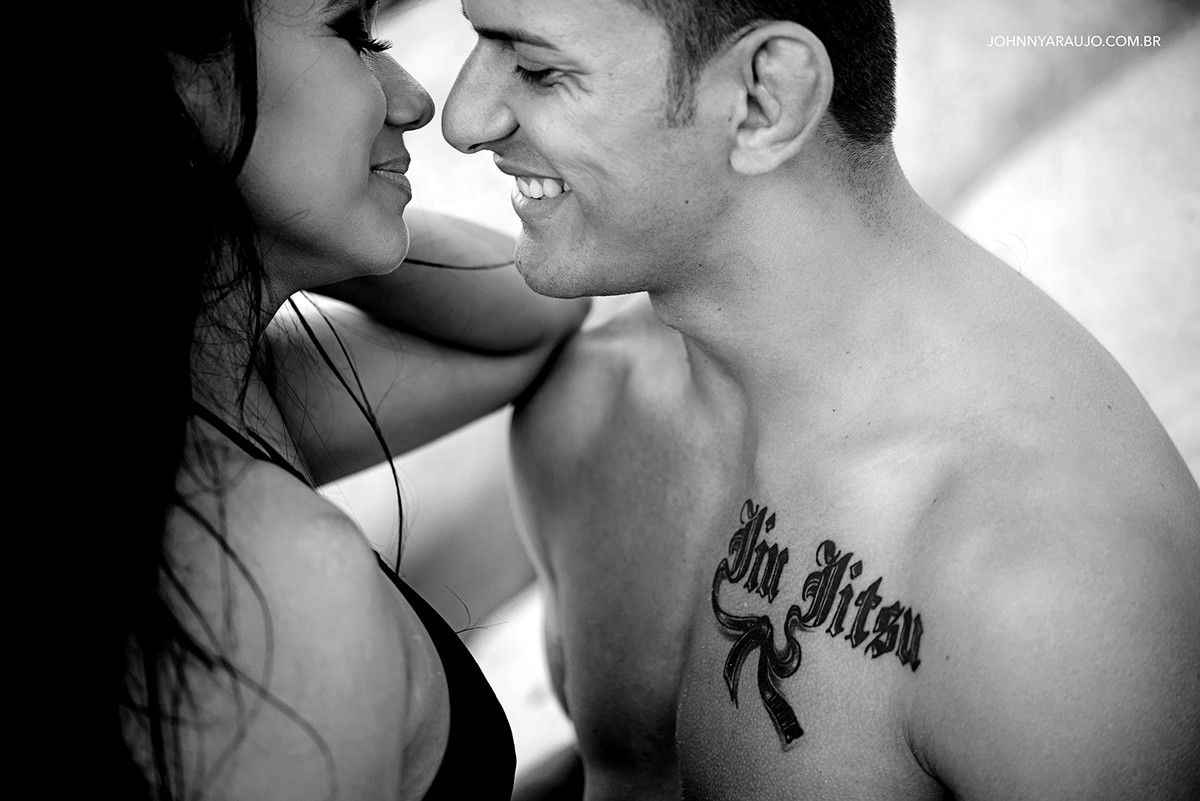 casal à vontade na praia, sorrindo quase se beijando registrado pelo fotógrafo de casamento Johnny Araújo em Tabatinga PB