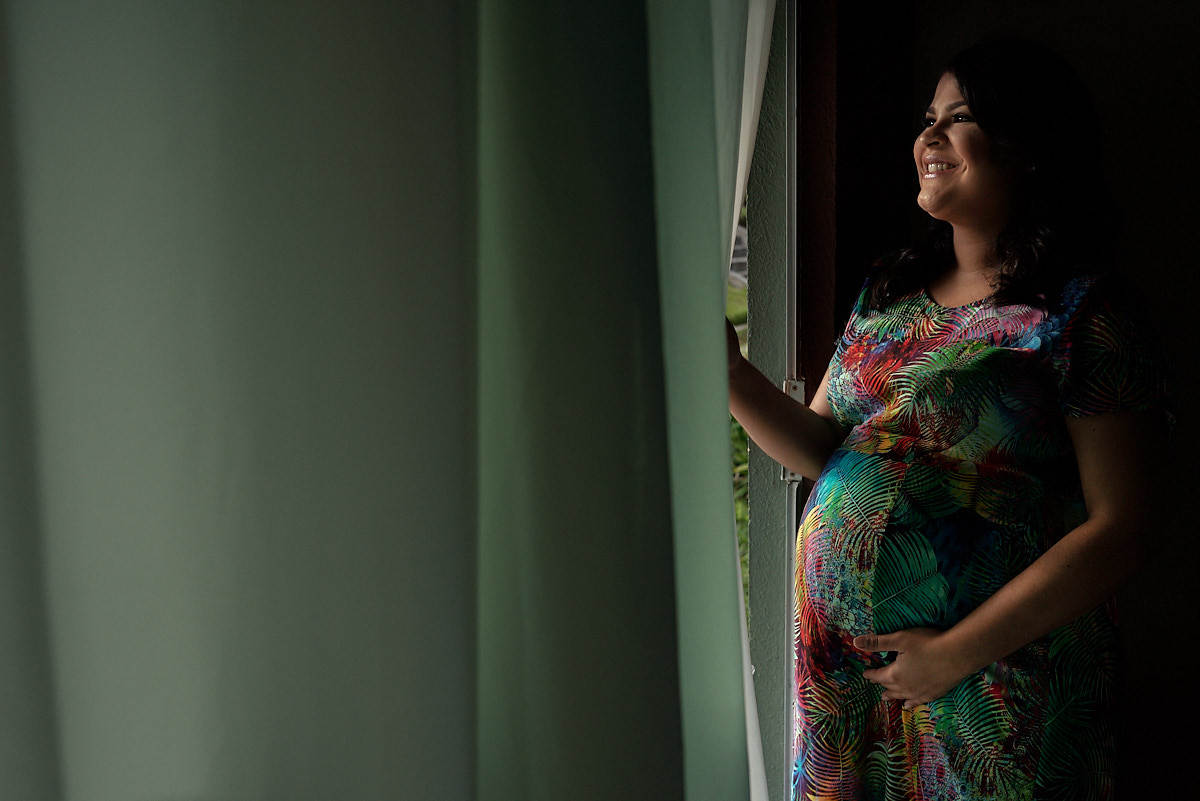 mãe com luz de janela, segurando a cortina