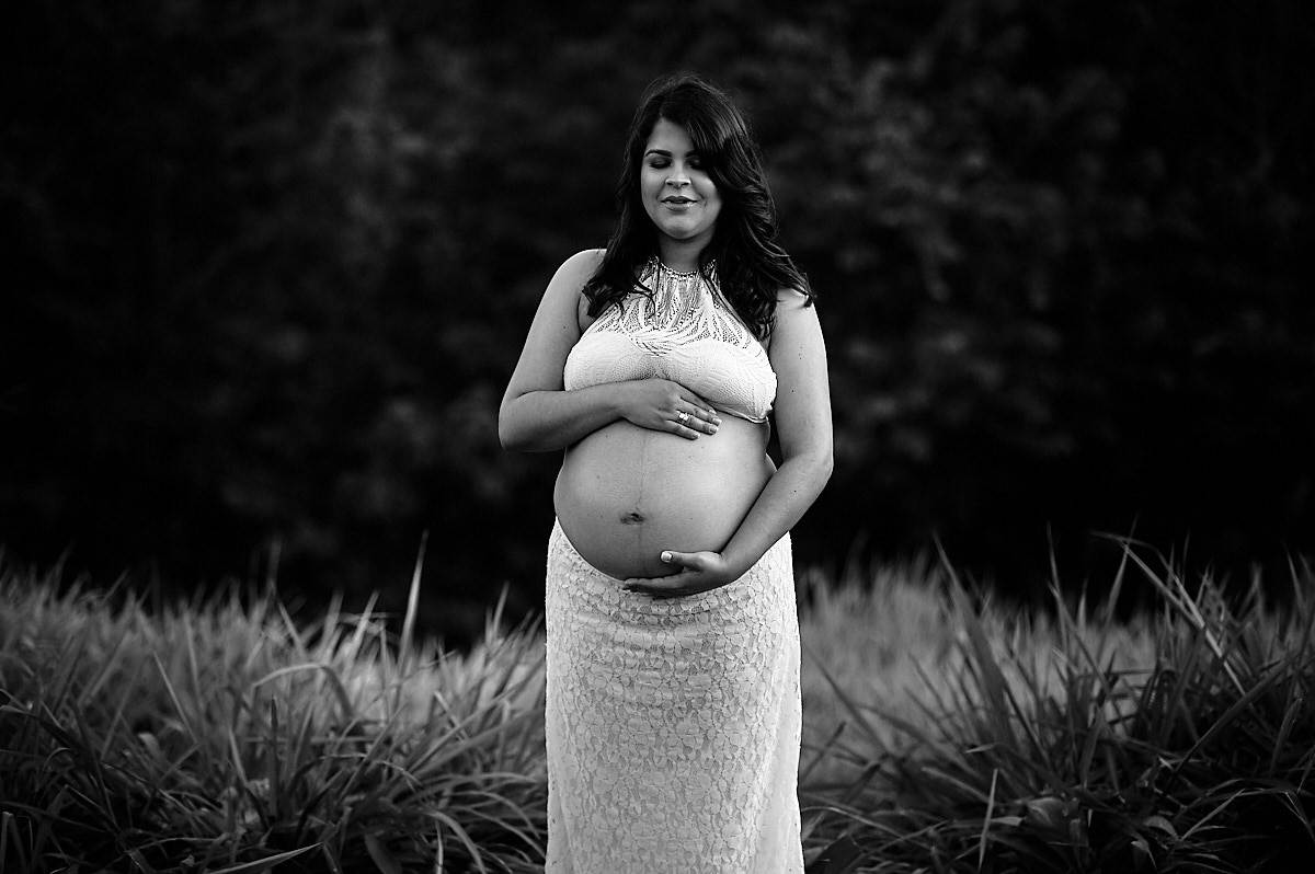 mãe com folhagens verde ao fundo, foto em preto e branco
