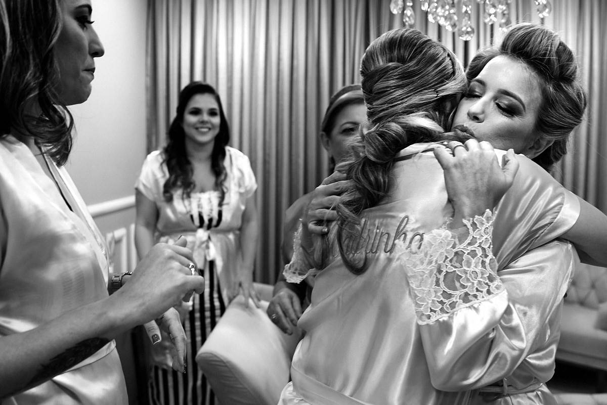 casamento de larissa e thiago por 4Mãos fotografias, noiva no making of abraçando as madrinhas, foto em preto e branco
