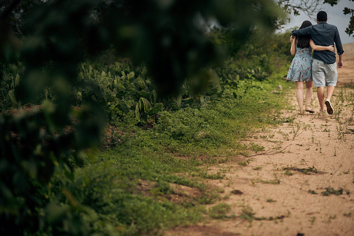 ensaio de Jessica e Ewerton no Rancho do Cajú na cidade de Pocinhos Paraíba, casal caminhando na estrada de terra