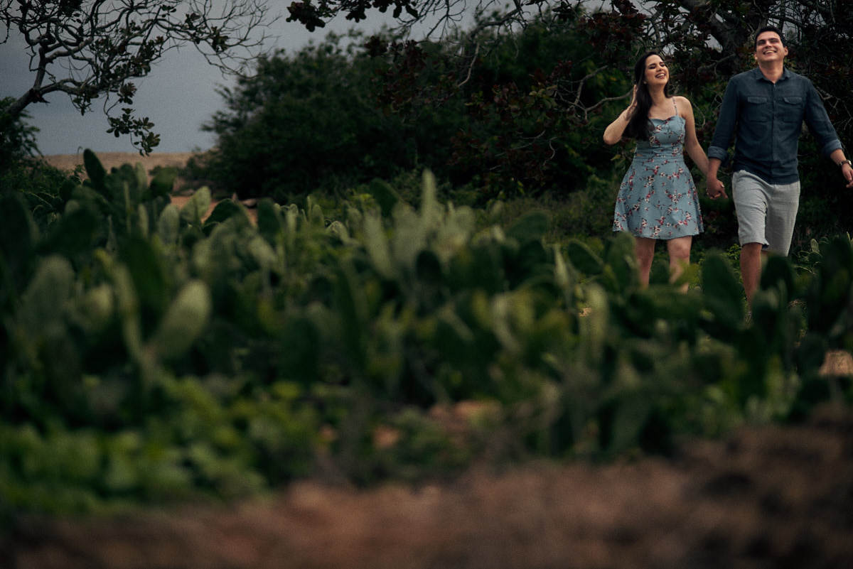 ensaio de Jessica e Ewerton no Rancho do Cajú na cidade de Pocinhos Paraíba, casal caminhando na estrada, plantação de palma