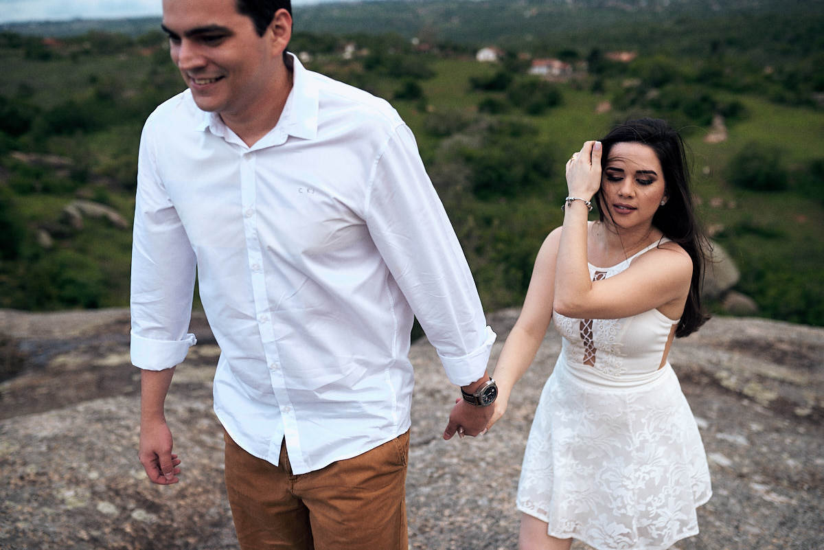 ensaio de Jessica e Ewerton no Rancho do Cajú na cidade de Pocinhos Paraíba, casal caminhando, cabelo da noiva voando