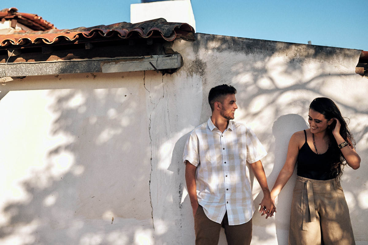 ensaio de Fernanda e Lucas em Catolé de Boa Vista no sitio do sua avó, casal de mão dadas e casal ao fundo, sombra de árvore na parede