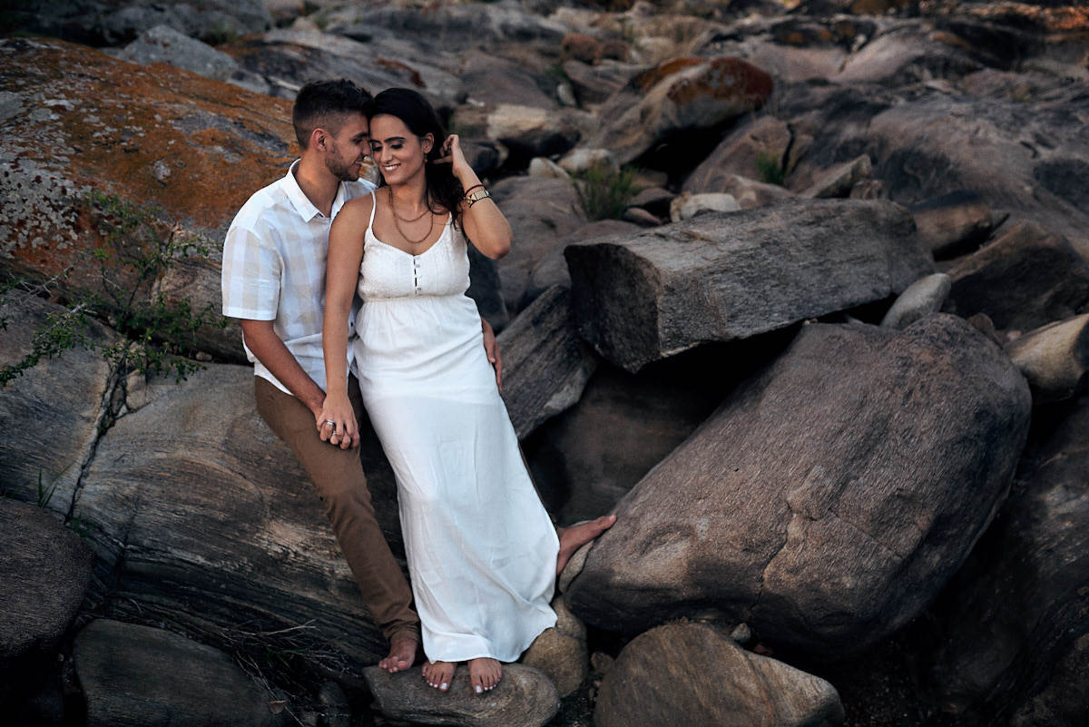 ensaio de Fernanda e Lucas em Catolé de Boa Vista no sitio do sua avó, sentados namorando em pedras por onde passa o rio