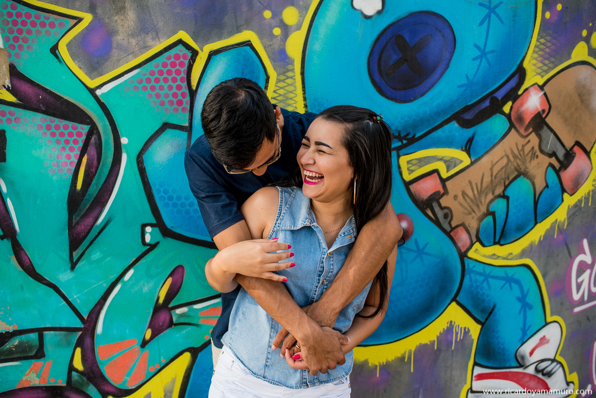 ensaio-fotografico-nas-ruas-de-aracatuba-casal-se-divertindo-proximos-parede-com-grafite