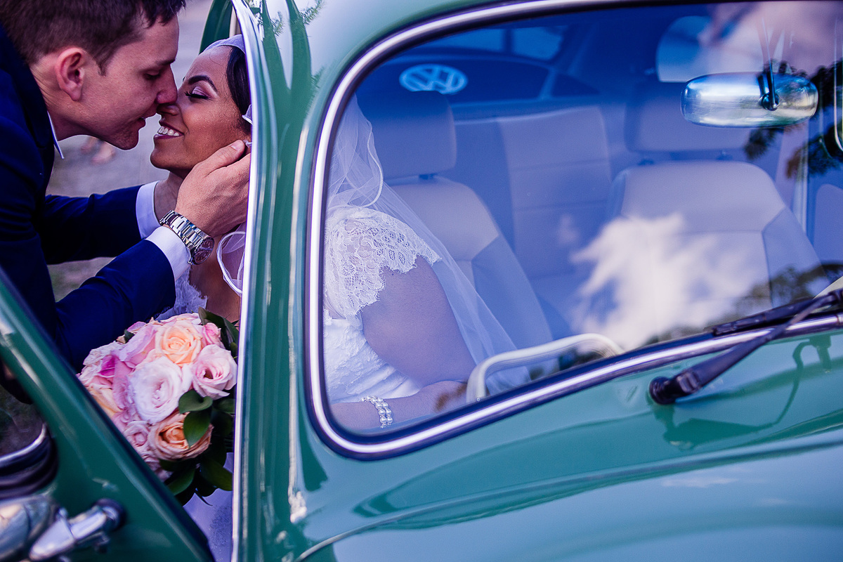 Fotografia de casamento noivo e noiva se beijando fusca restaurado