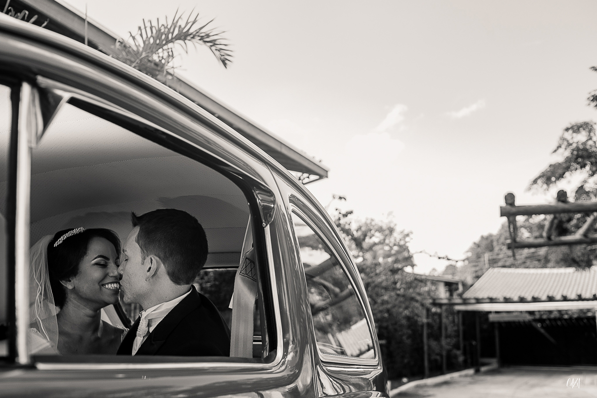 Fotografia de casamento noivo e noiva se beijando fusca antigo