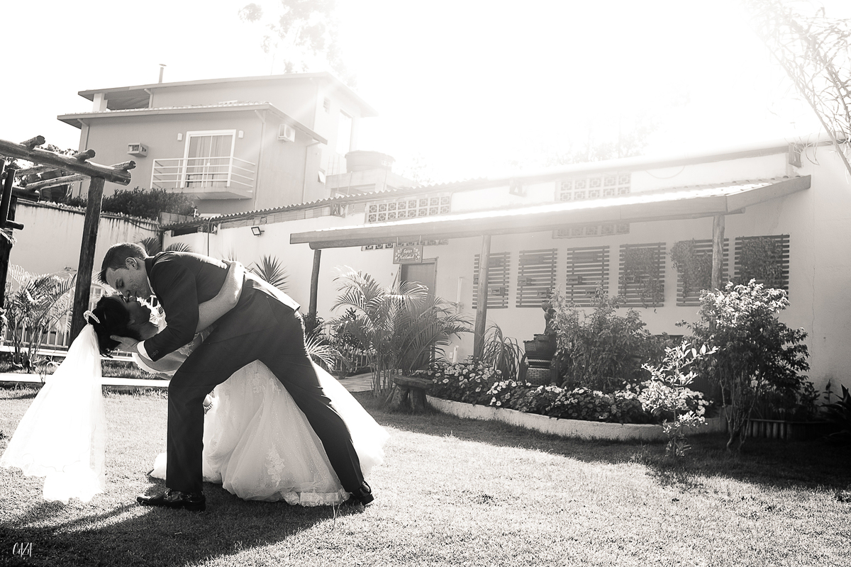Fotografia de casamento noivo e noiva se beijando ao ar livre preto e branco com vestido e véu