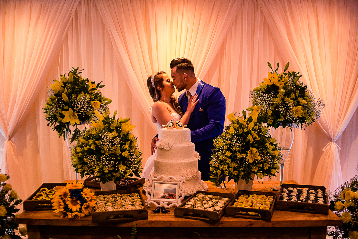Fotografia de casamento recepção mesa de bolo, doces e decoração noivo e noiva