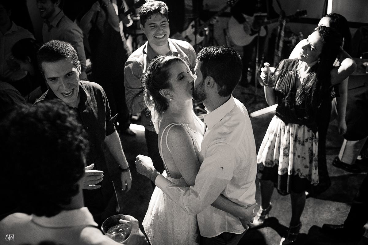 Fotografia casamento recepção  noiva e convidados pista de dança se beijando com banda de rock