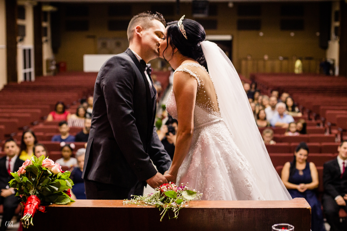 Fotografia de casamento cerimônia noivo e noiva se beijando no altar