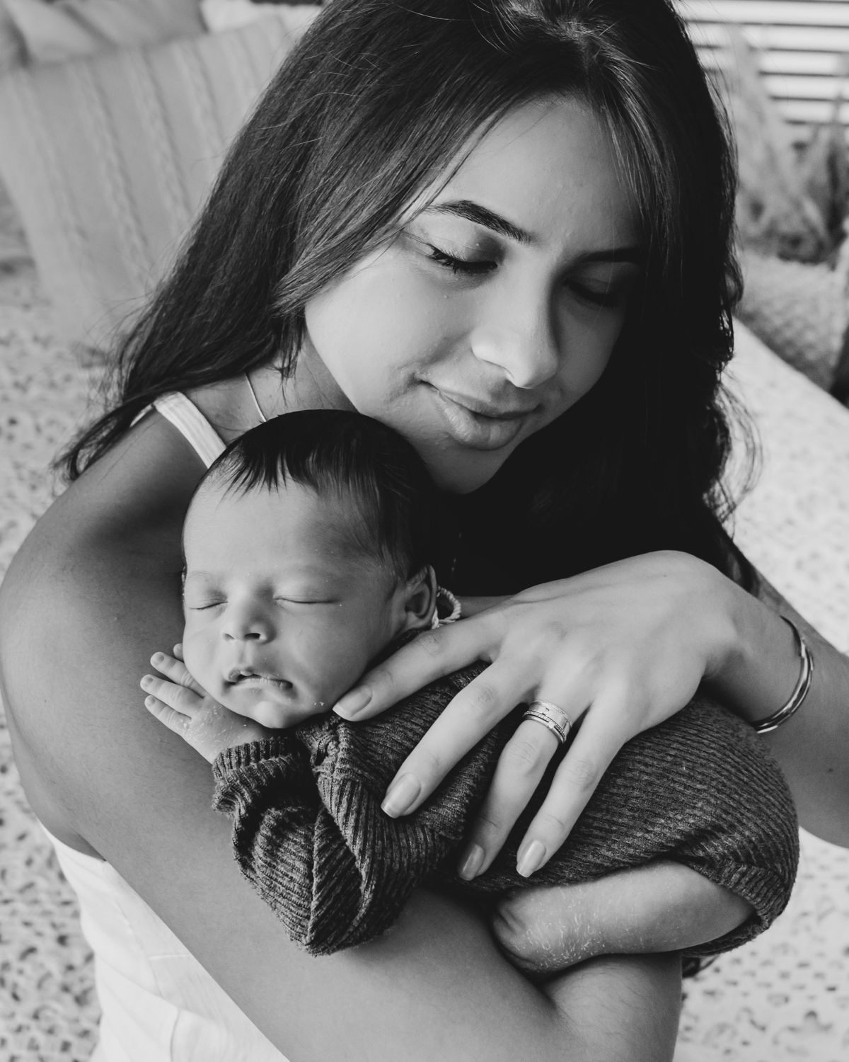 mãe morena com bebe em seu ombro dormindo