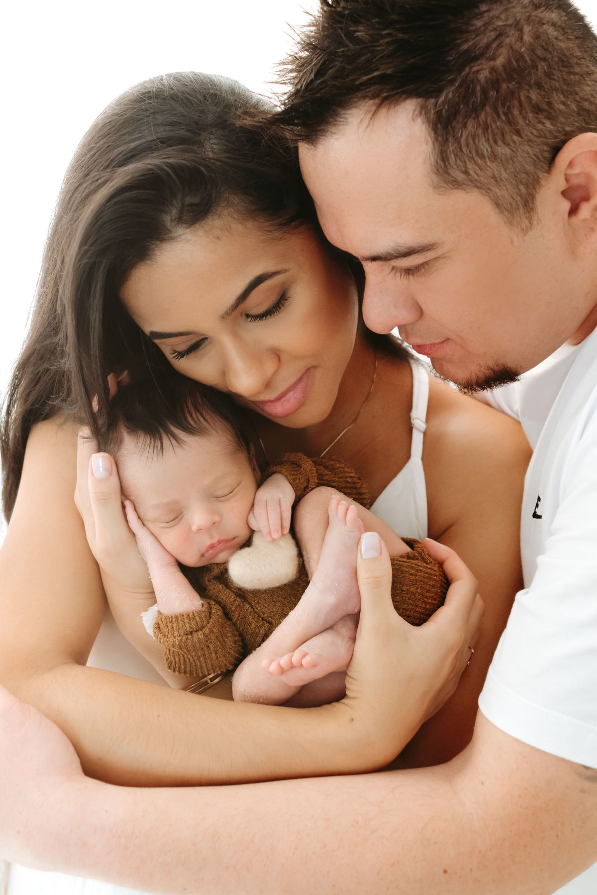 mãe, pai e bebe. bebe segurando um coração de feltro