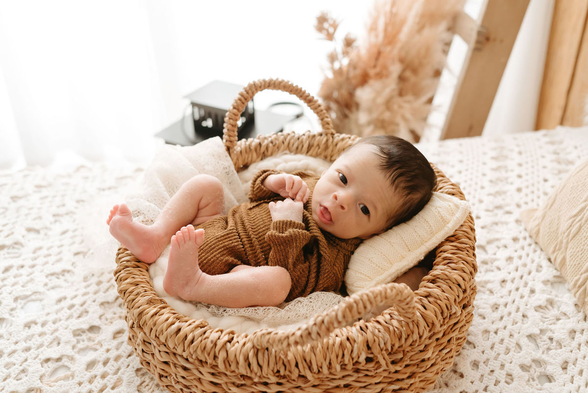 bebe deitado em um baldinho de vime