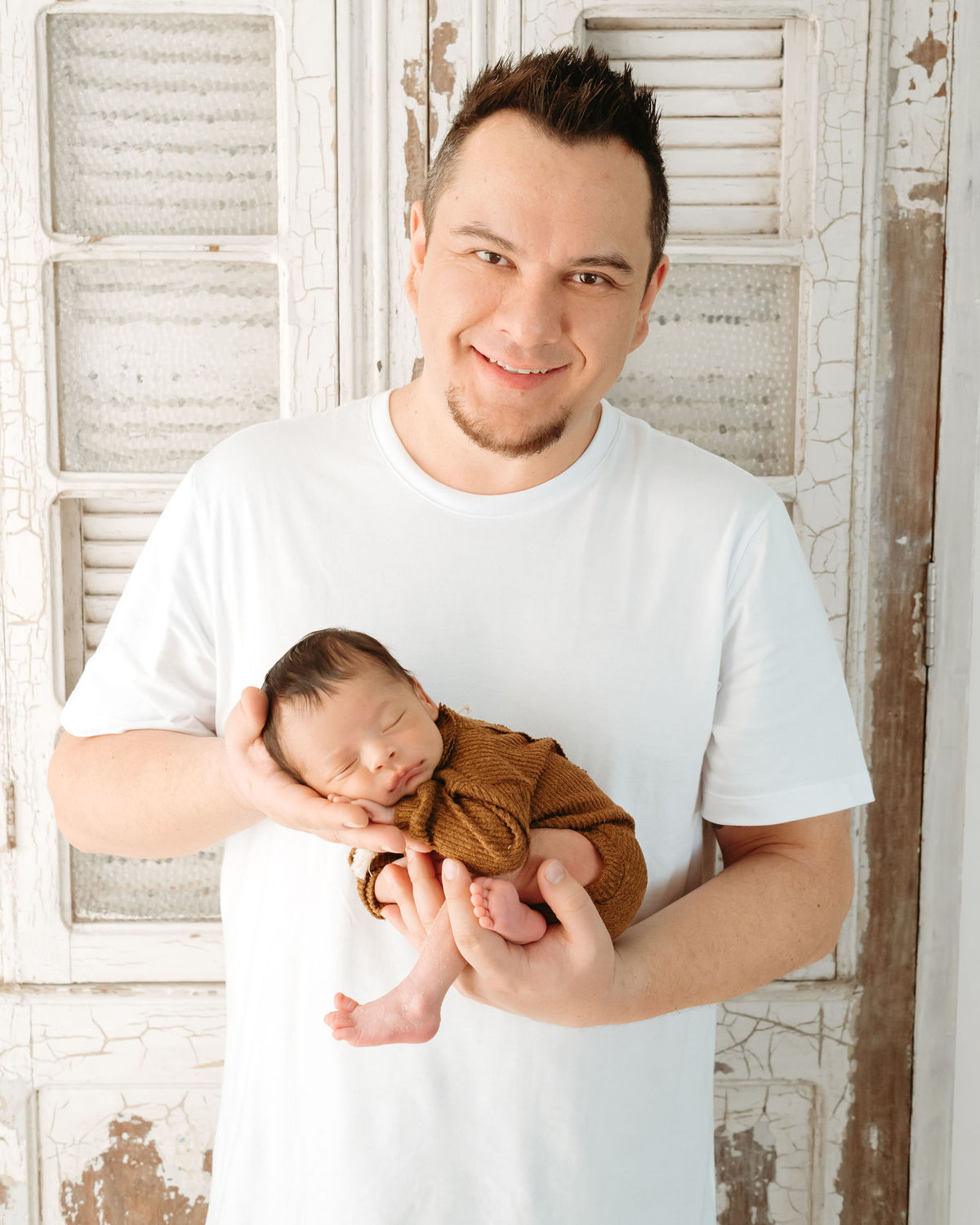 pai branco segurando bebe recém nascido