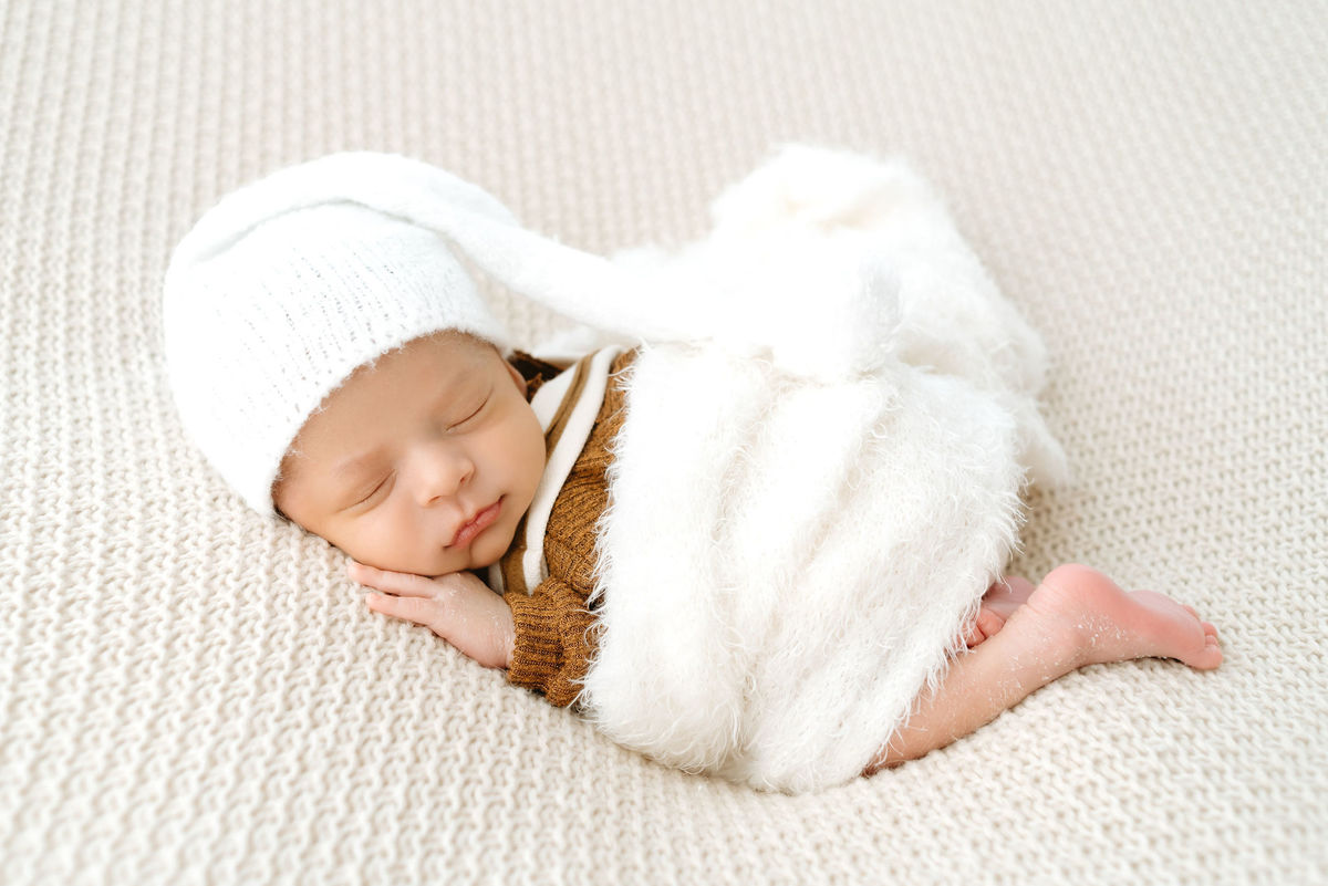 bebe deitado de barriga para baixo com paninho em volta