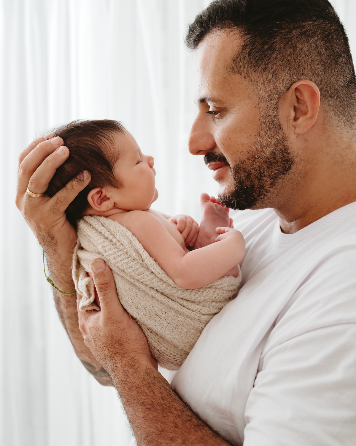 Pai segurando um bebe com rosto próximo