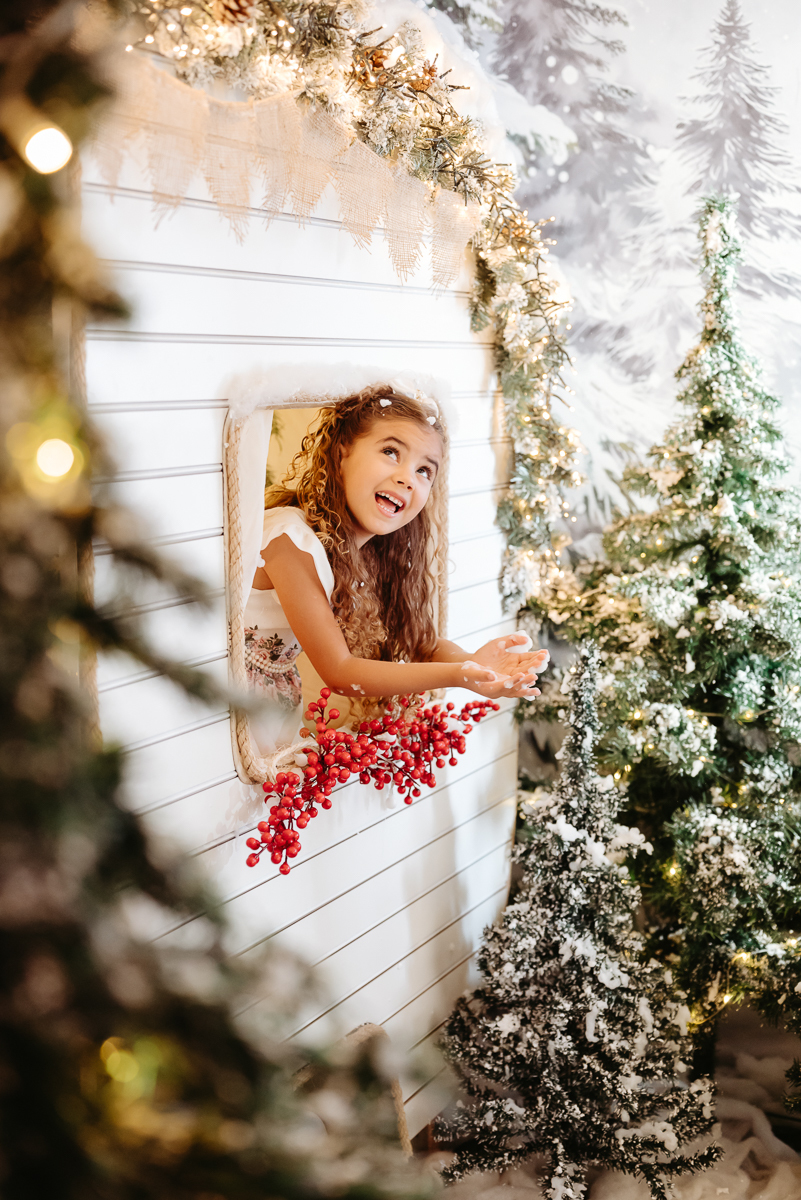 menina de cabelos longos loiro olhando para cima e vendo a neve realista caindo em cenário de natal