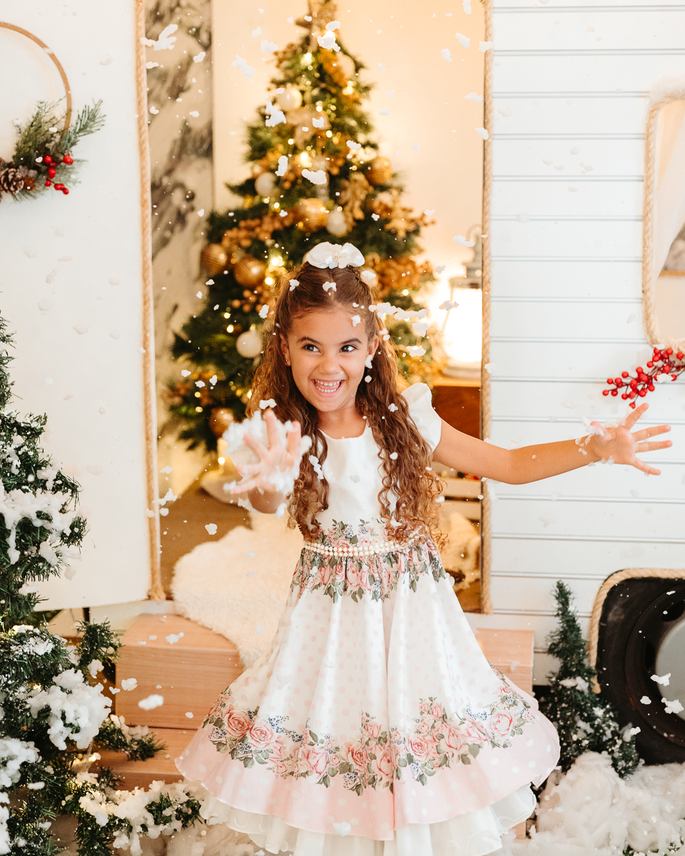 menina se divertindo pegando neve de verdade caindo com cenário de trailer ao fundo