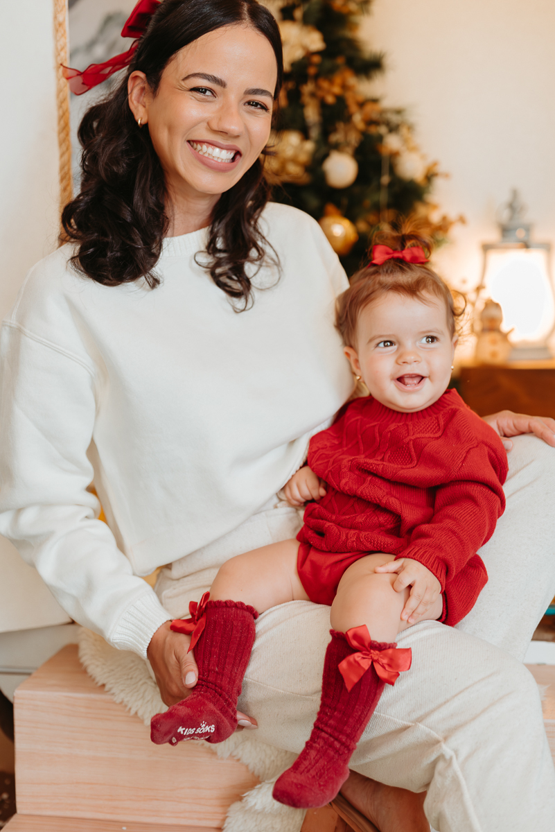 mãe e filha com muita alegria. bebe veste roupa vermelha e mãe blusa branca