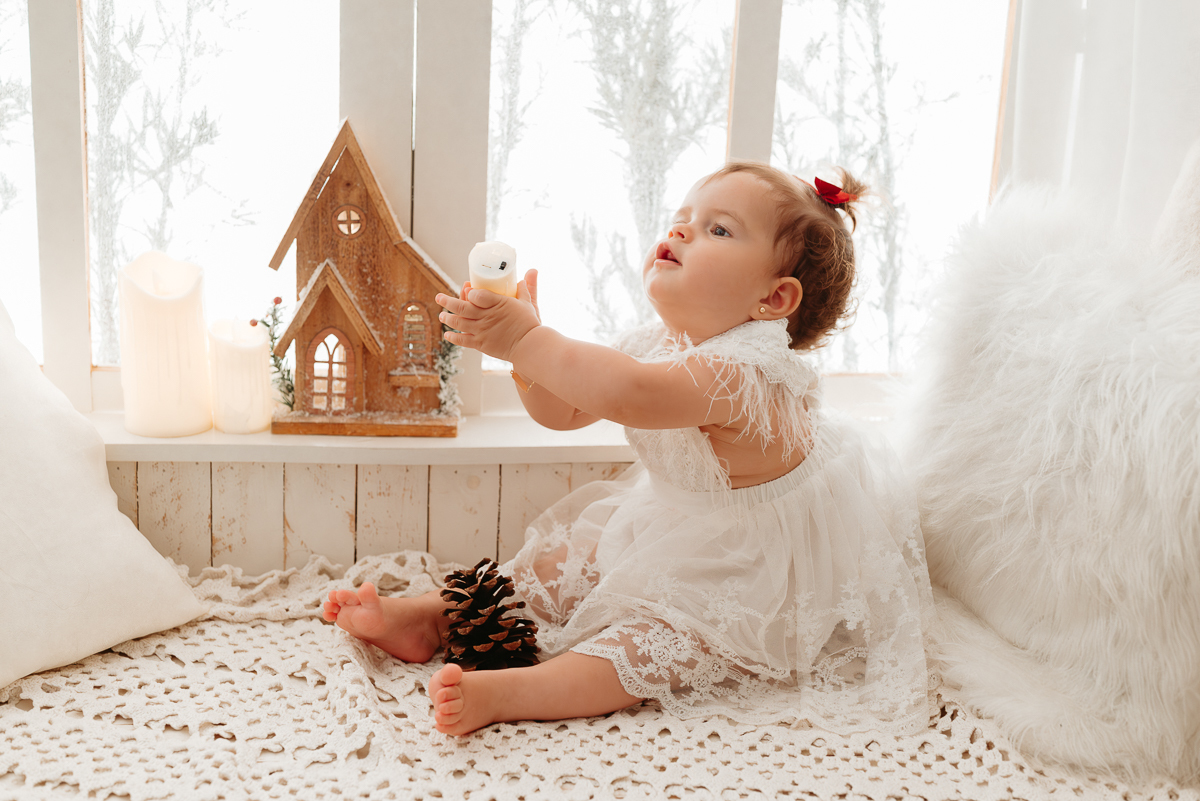 menina bebe vestindo vestido branco batendo palmilhas