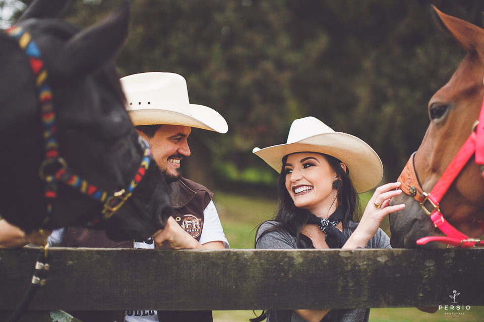 casal se olhando fazendo fotos com cavalos na chacara capela das graças em araucaria parana ensaio com os fotografos persio photo art