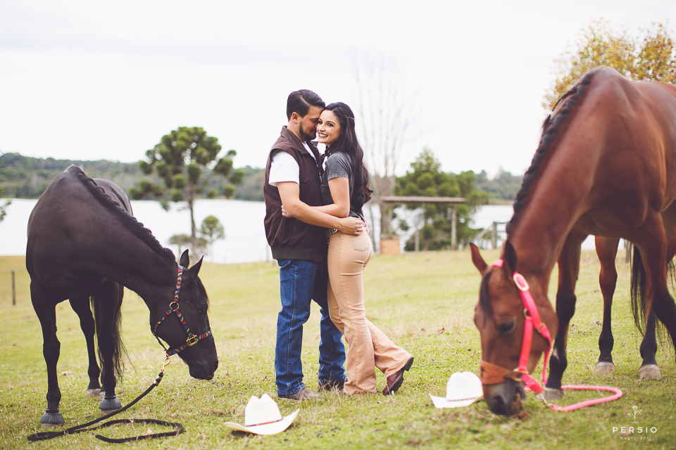 casal se olhando fazendo fotos com cavalos na chacara capela das graças em araucaria parana ensaio com os fotografos persio photo art fazendo ensaio prewedding para o casamento