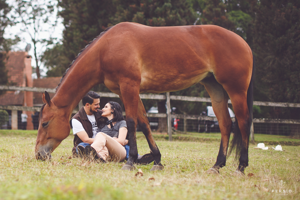 casal se olhando fazendo fotos com cavalos na chacara capela das graças em araucaria parana ensaio com os fotografos persio photo art