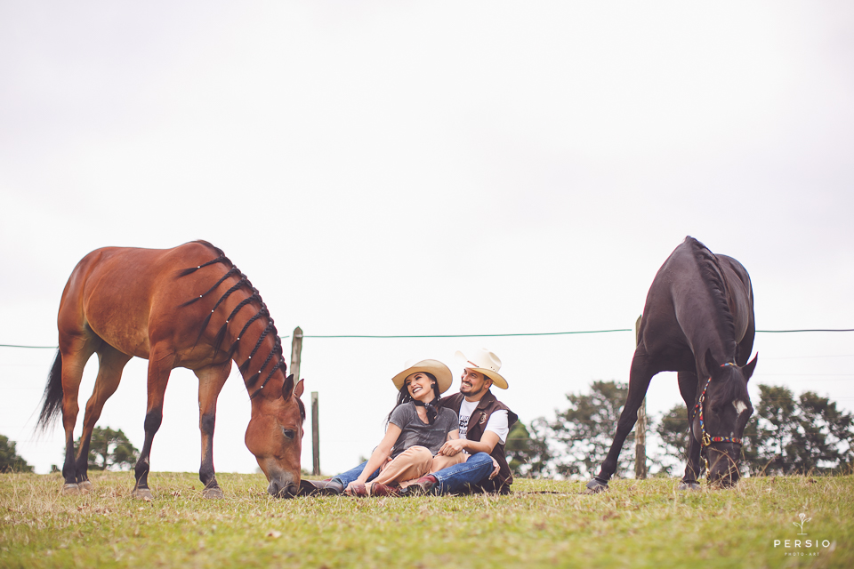 casal se olhando fazendo fotos com cavalos na chacara capela das graças em araucaria parana ensaio com os fotografos persio photo art olhando para os cavalos