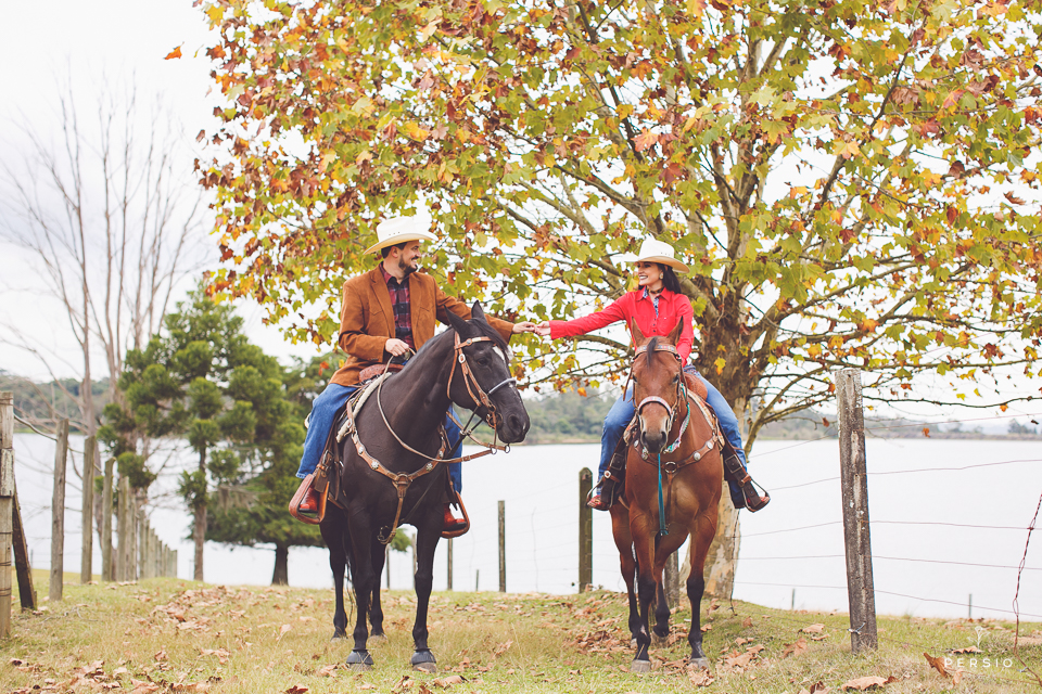 casal se olhando fazendo fotos com cavalos na chacara capela das graças em araucaria parana ensaio com os fotografos persio photo art
