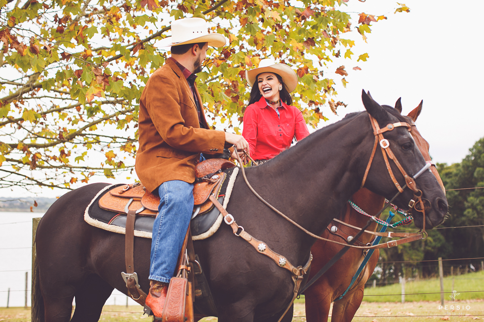 casal se olhando fazendo fotos com cavalos na chacara capela das graças em araucaria parana ensaio com os fotografos persio photo art