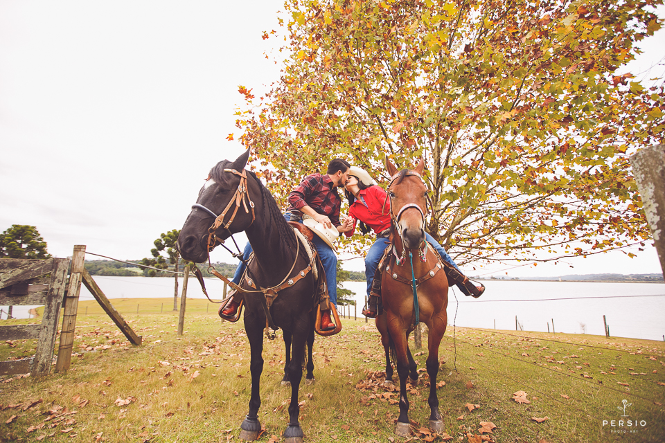 casal se olhando fazendo fotos com cavalos na chacara capela das graças em araucaria parana ensaio com os fotografos persio photo art