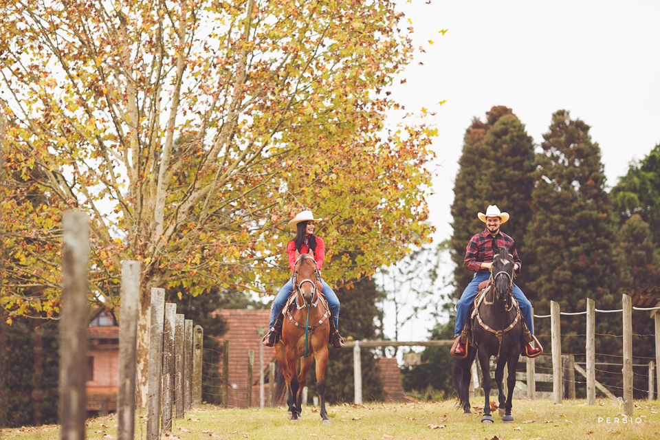 casal se olhando fazendo fotos com cavalos na chacara capela das graças em araucaria parana ensaio com os fotografos persio photo art