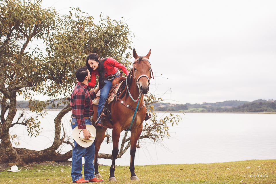 casal se olhando fazendo fotos com cavalos na chacara capela das graças em araucaria parana ensaio com os fotografos persio photo art