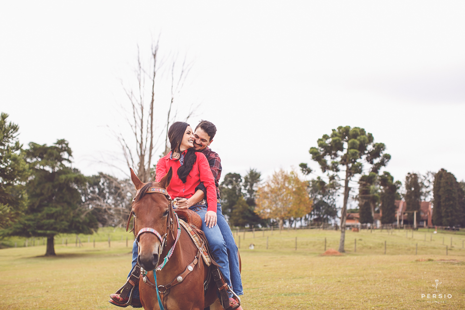 casal se olhando fazendo fotos com cavalos na chacara capela das graças em araucaria parana ensaio com os fotografos persio photo art